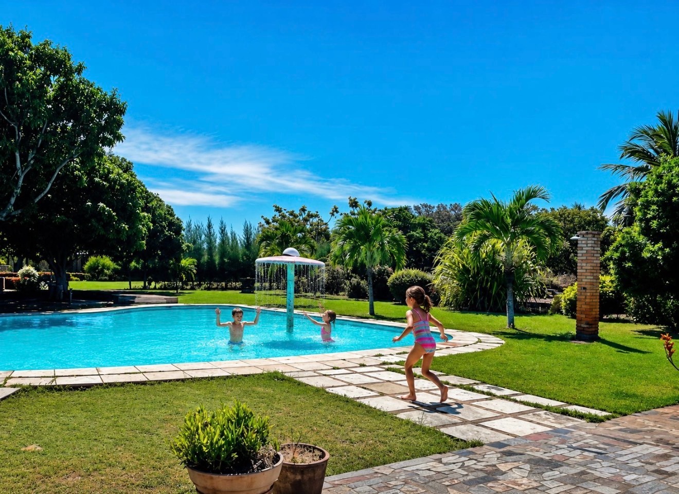 Children playing by the pool in the tropical gardens