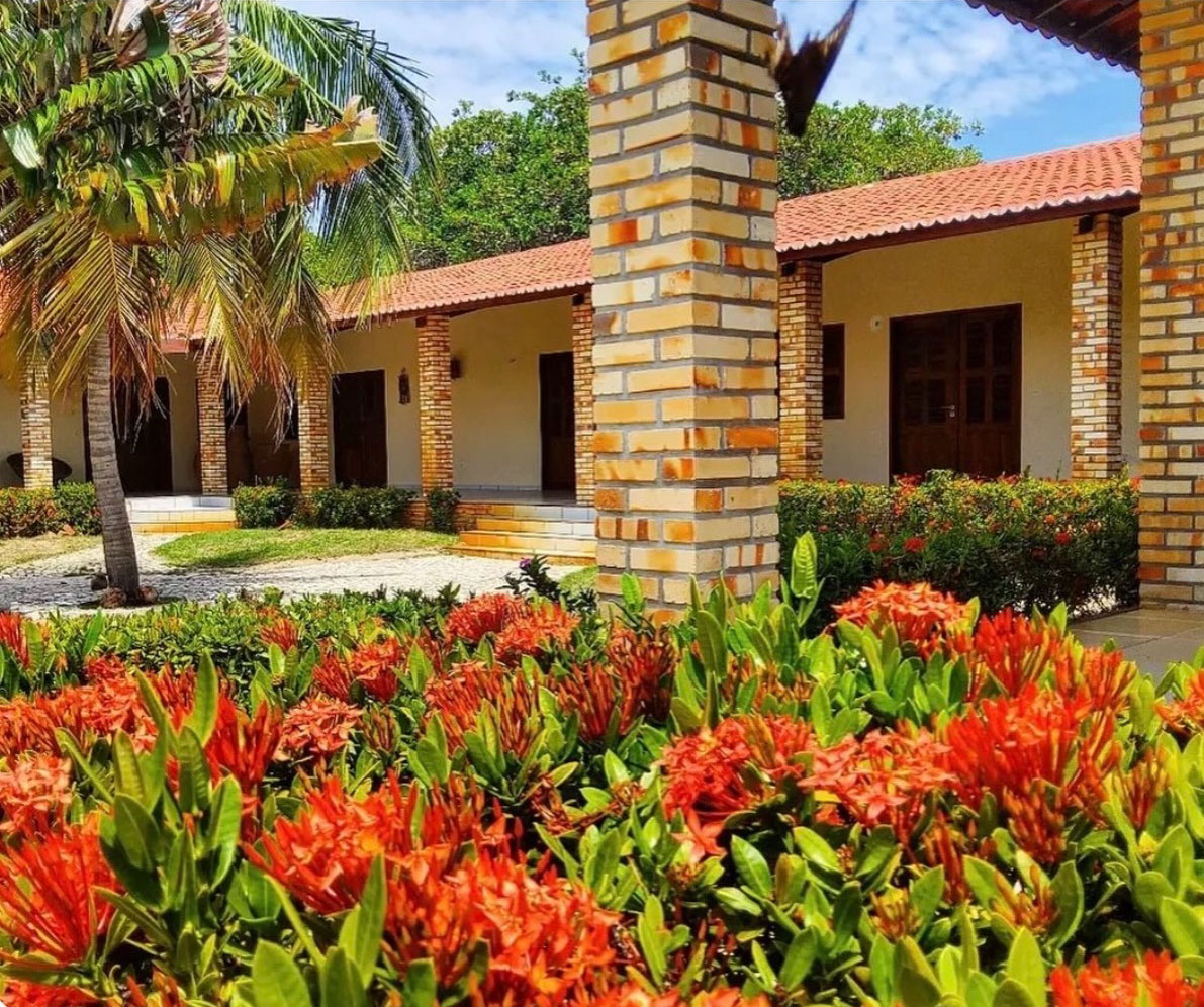 Suites of Vila dos Oito with brick columns and tropical flowers